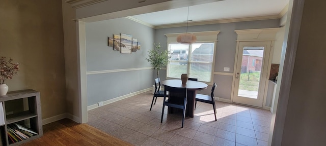 dining room featuring baseboards, tile patterned flooring, and crown molding