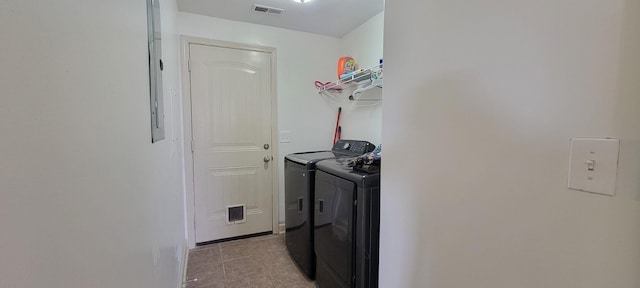 laundry area with laundry area, washing machine and clothes dryer, and visible vents