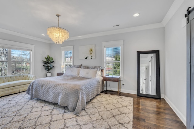 bedroom with visible vents, crown molding, multiple windows, and a barn door