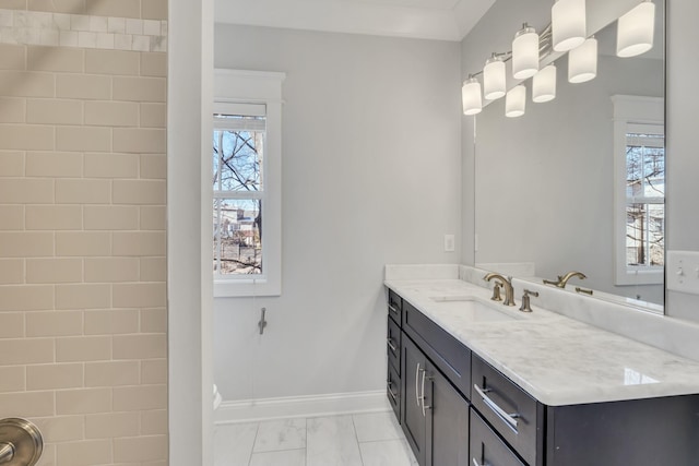 bathroom with marble finish floor, ornamental molding, vanity, and baseboards