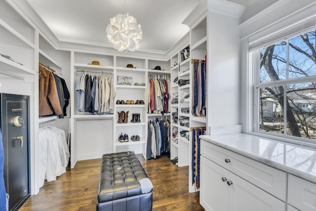 spacious closet featuring a chandelier and dark wood finished floors