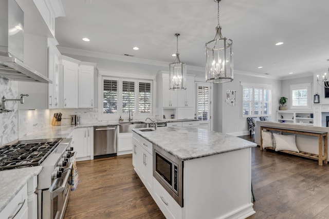 kitchen with stainless steel appliances, backsplash, wall chimney range hood, and dark wood-style floors