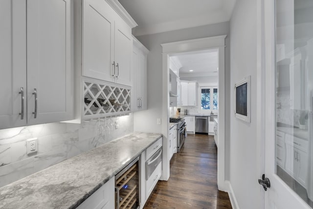 bar featuring dark wood finished floors, tasteful backsplash, appliances with stainless steel finishes, ornamental molding, and beverage cooler