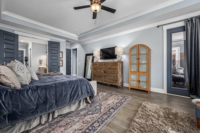 bedroom featuring ceiling fan, wood finished floors, baseboards, a raised ceiling, and crown molding