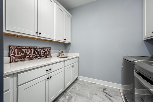 laundry area with a sink, baseboards, marble finish floor, cabinet space, and washing machine and clothes dryer