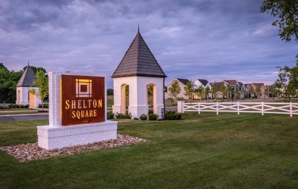 community / neighborhood sign featuring fence and a yard