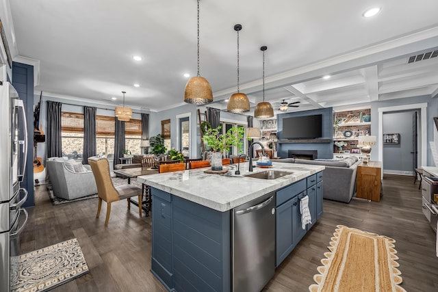 kitchen featuring blue cabinetry, visible vents, open floor plan, a sink, and dishwasher