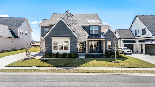 view of front of property with roof with shingles, concrete driveway, a front yard, a standing seam roof, and metal roof