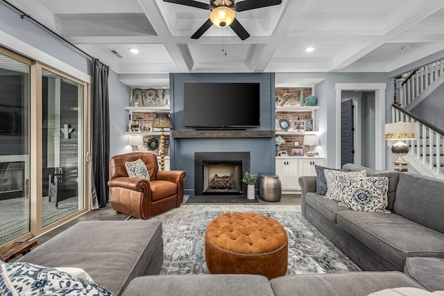 living room featuring stairs, a fireplace, coffered ceiling, and beam ceiling