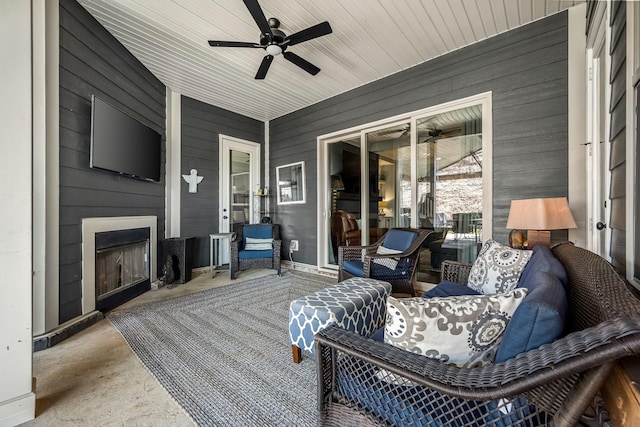 exterior space with a ceiling fan and a large fireplace