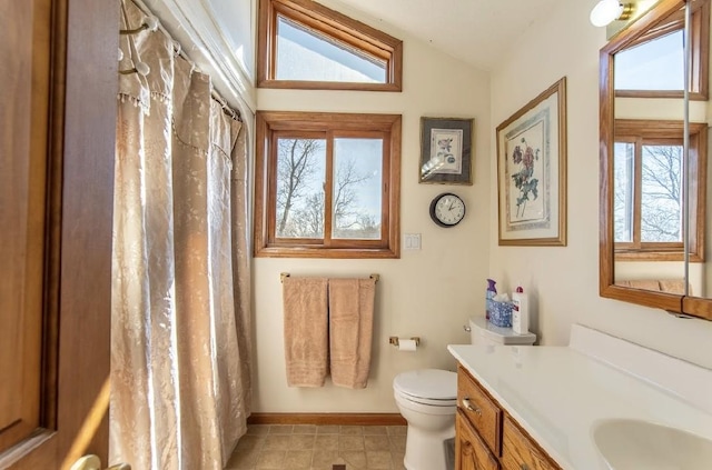 full bath featuring baseboards, toilet, curtained shower, vaulted ceiling, and vanity