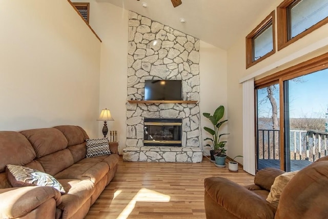 living room with high vaulted ceiling, a ceiling fan, a fireplace, and wood finished floors