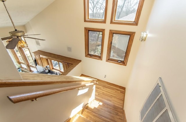 stairs featuring a ceiling fan, visible vents, and wood finished floors