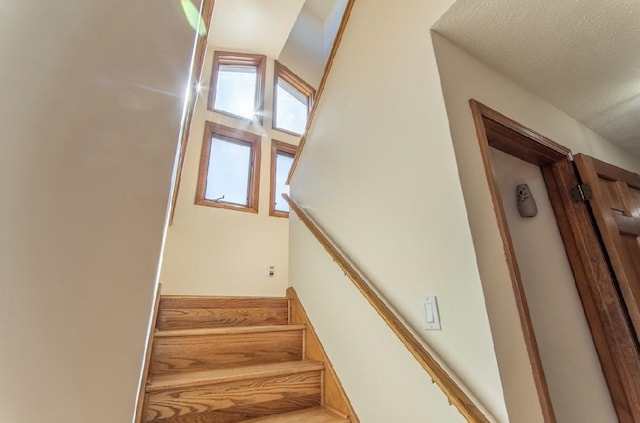 stairs featuring a textured ceiling