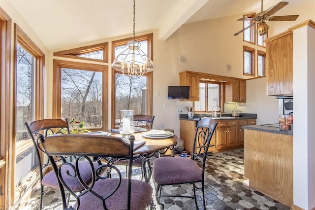 dining room with ceiling fan with notable chandelier, high vaulted ceiling, and beam ceiling