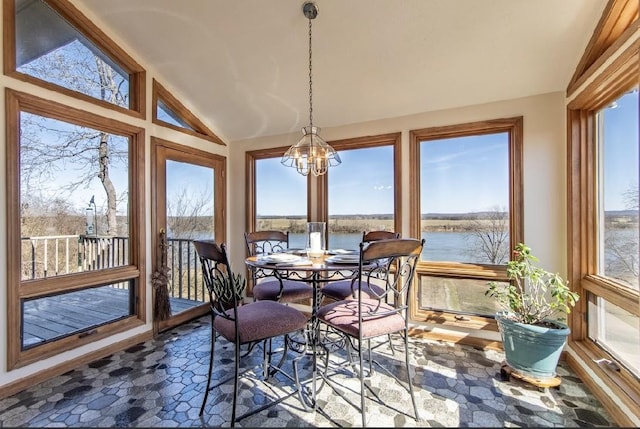 sunroom featuring vaulted ceiling, a water view, and an inviting chandelier