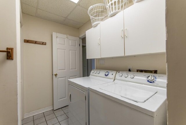 laundry room featuring cabinet space, light tile patterned floors, baseboards, and separate washer and dryer