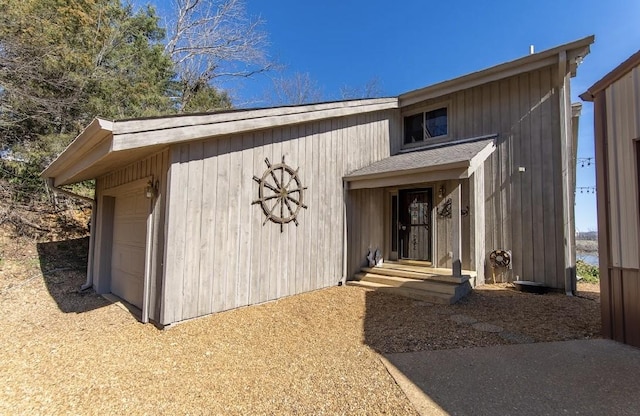 doorway to property featuring a garage and driveway