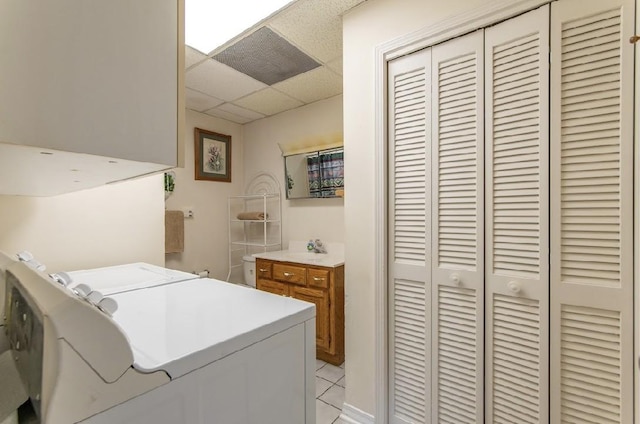 laundry area featuring laundry area, washing machine and dryer, light tile patterned floors, and a sink