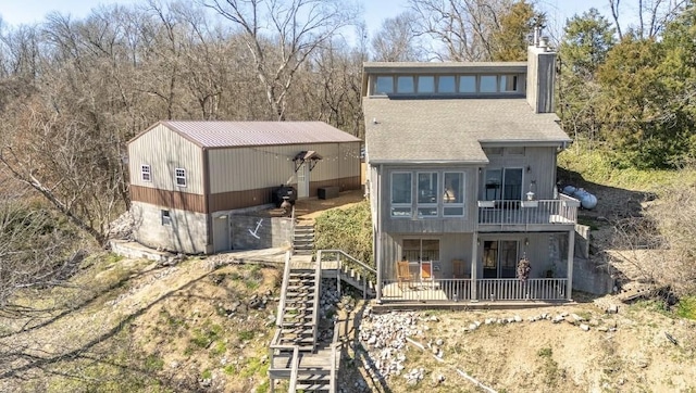 rear view of house featuring a chimney, stairway, and a patio