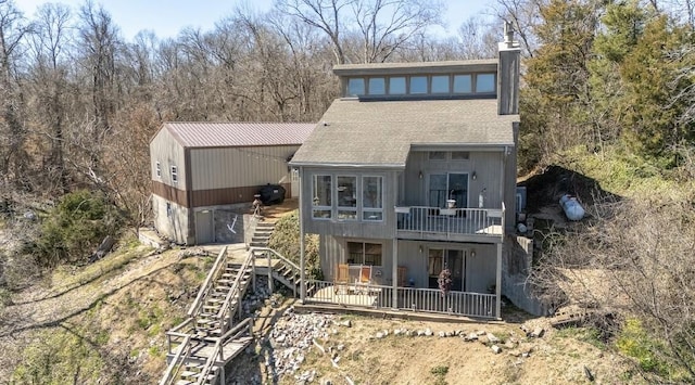 rear view of property featuring a patio, a chimney, and stairs