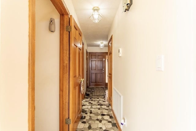 hallway featuring visible vents and a textured ceiling