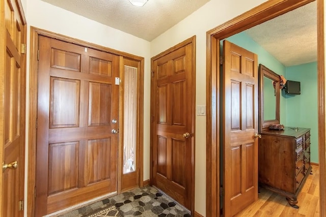 entryway featuring a textured ceiling and baseboards