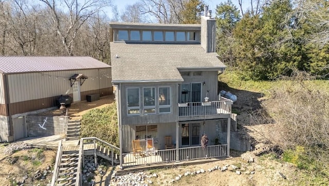 back of property featuring central AC unit, a shingled roof, a chimney, and stairway