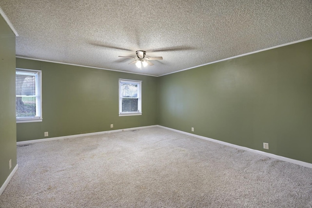 unfurnished room featuring a ceiling fan, carpet flooring, crown molding, and baseboards