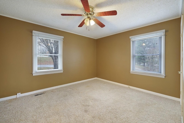 carpeted spare room with a textured ceiling, ceiling fan, visible vents, and baseboards