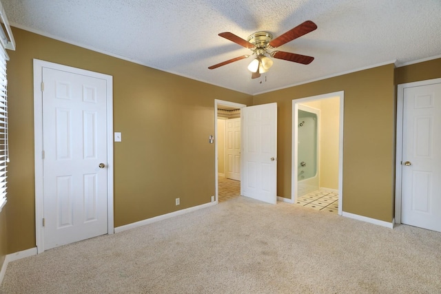 unfurnished bedroom featuring a textured ceiling, crown molding, carpet, and baseboards