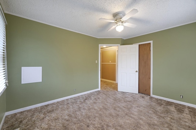 unfurnished bedroom with a textured ceiling, baseboards, carpet flooring, and ornamental molding