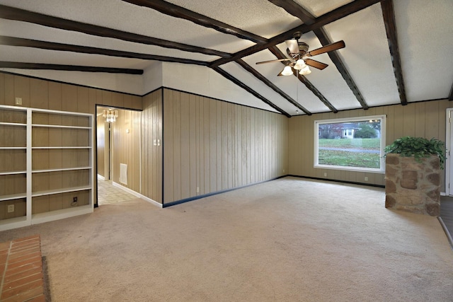 carpeted spare room with a ceiling fan, visible vents, vaulted ceiling with beams, and a textured ceiling