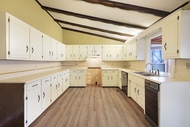 kitchen featuring black dishwasher, vaulted ceiling with beams, a sink, a textured ceiling, and under cabinet range hood