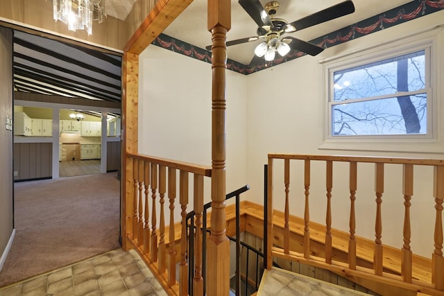 hallway with carpet floors, vaulted ceiling with beams, and an upstairs landing