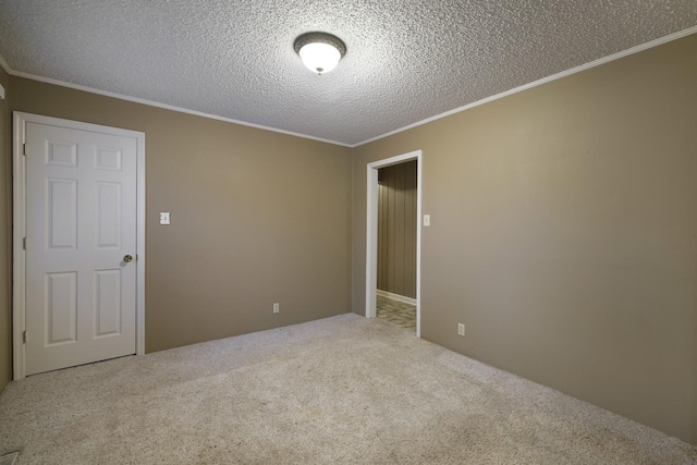 empty room with carpet, crown molding, and a textured ceiling