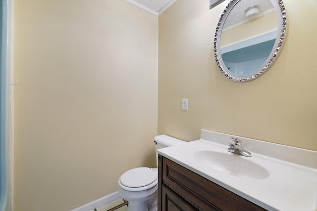 half bathroom featuring toilet, baseboards, a textured ceiling, and vanity