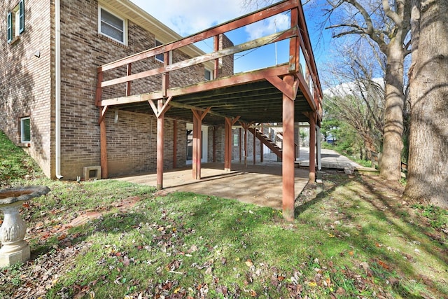 back of house with a patio area, a wooden deck, stairway, and brick siding