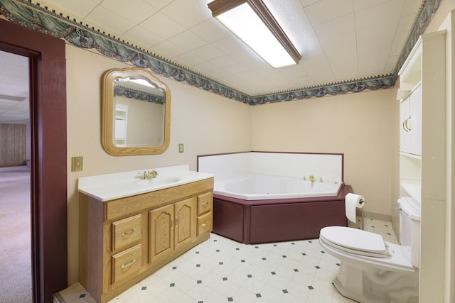 bathroom featuring toilet, vanity, and a bath