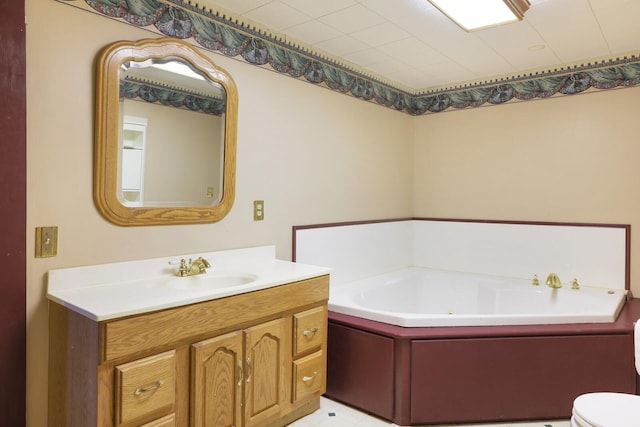 bathroom with toilet, a garden tub, and vanity