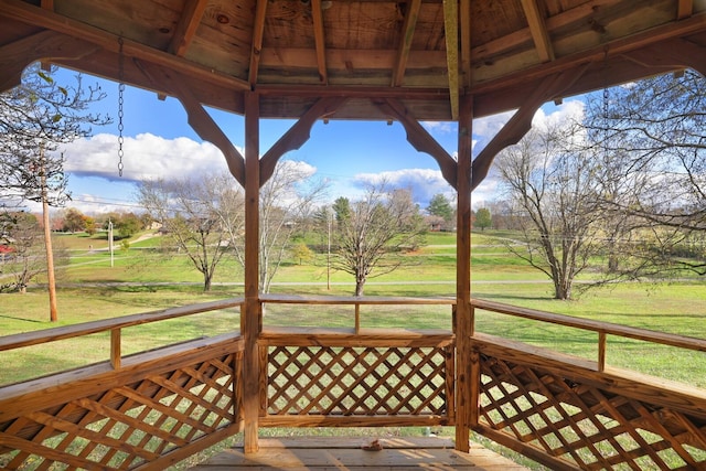 wooden terrace featuring a yard and a gazebo