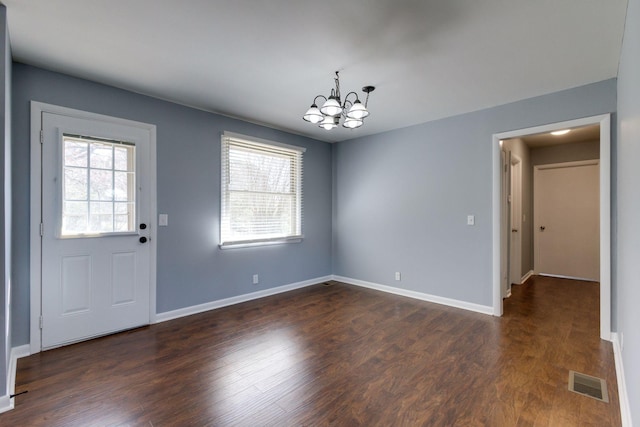 interior space featuring plenty of natural light, dark wood finished floors, visible vents, and a notable chandelier