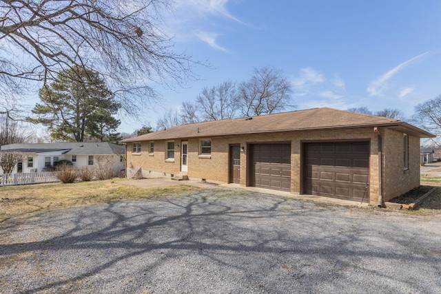 view of front facade with a garage, driveway, and brick siding