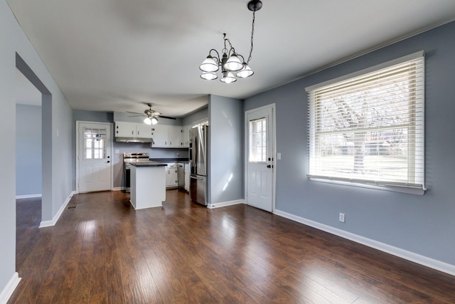 kitchen with dark wood-style flooring, white cabinetry, appliances with stainless steel finishes, a wealth of natural light, and dark countertops