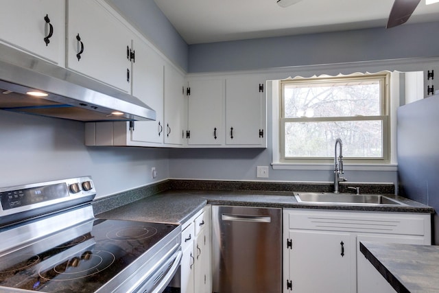 kitchen with stainless steel appliances, dark countertops, a sink, and under cabinet range hood