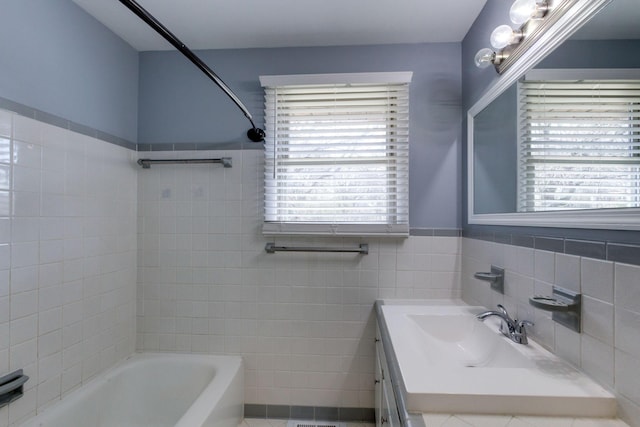 bathroom with tile walls, shower / bath combination, and vanity