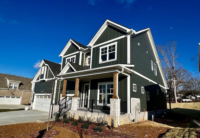 craftsman-style house with concrete driveway, a porch, board and batten siding, and an attached garage