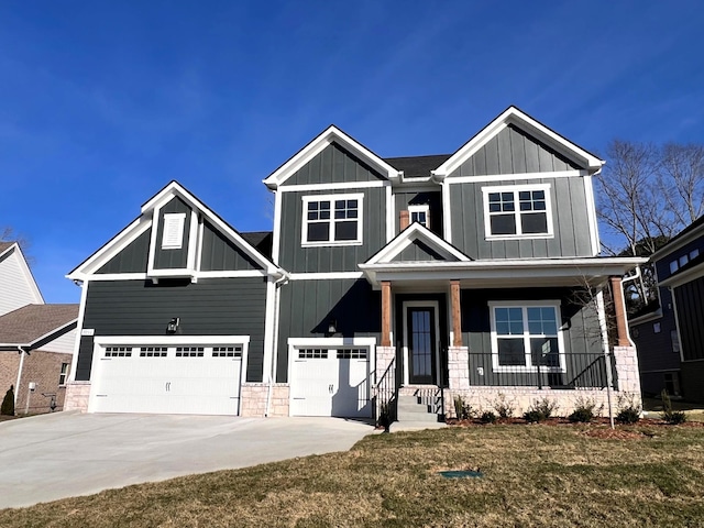 craftsman-style house featuring board and batten siding, covered porch, a garage, and concrete driveway