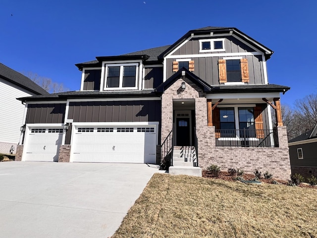 craftsman house featuring driveway, brick siding, board and batten siding, and an attached garage