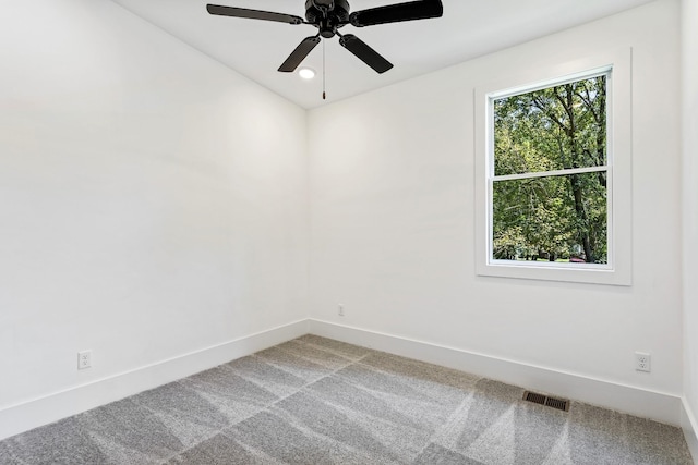 unfurnished room with carpet floors, a ceiling fan, visible vents, and baseboards